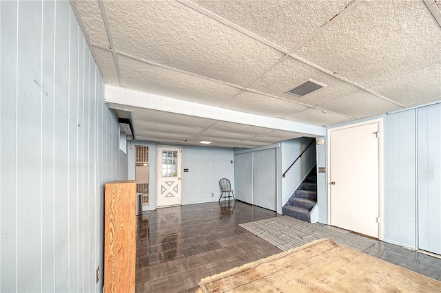 basement featuring wood walls and dark hardwood / wood-style flooring