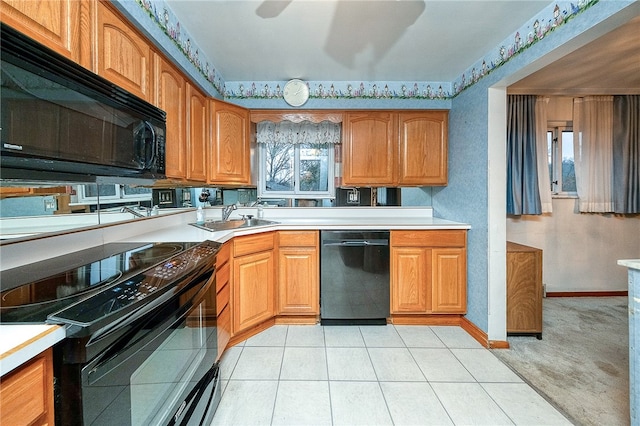 kitchen featuring sink, light tile patterned flooring, and black appliances