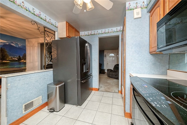 kitchen with stainless steel fridge, stove, light tile patterned floors, and ceiling fan