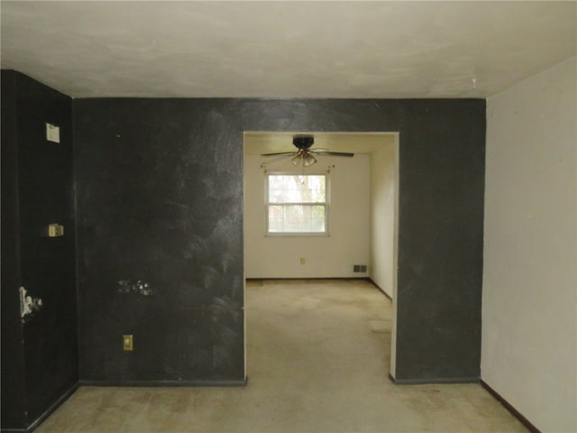 carpeted spare room with ceiling fan