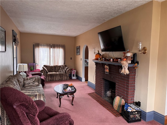 living room with carpet flooring, a textured ceiling, and a brick fireplace