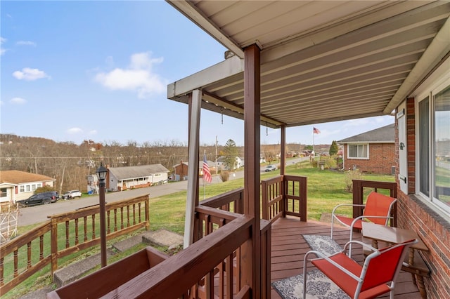 wooden terrace featuring a lawn