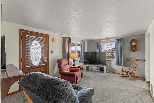 carpeted living room featuring a textured ceiling