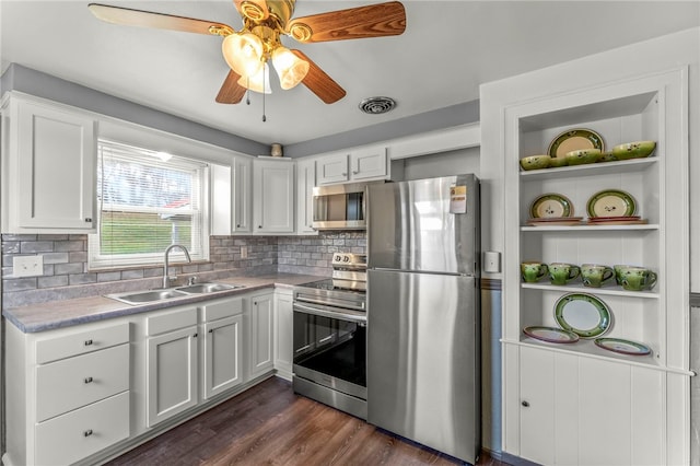 kitchen featuring sink, dark wood-type flooring, stainless steel appliances, backsplash, and white cabinets