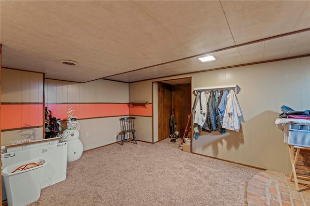 basement with wood walls and light colored carpet