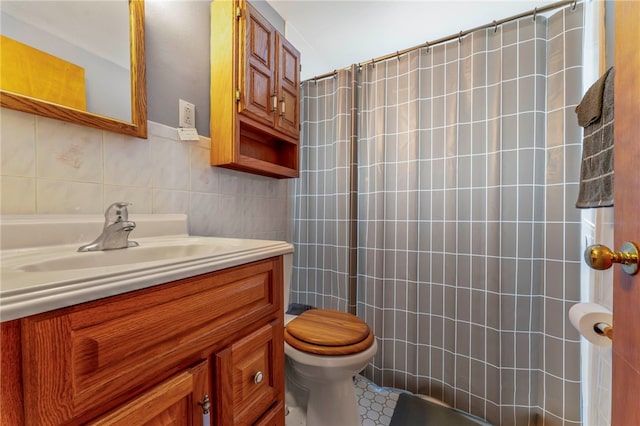 bathroom with vanity, toilet, tile walls, and walk in shower