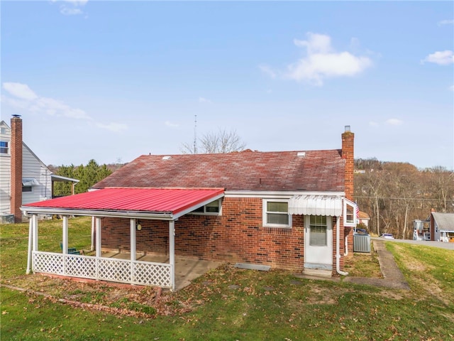 back of property with a lawn and a patio