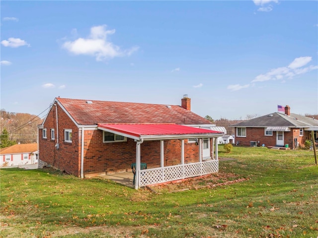 rear view of house featuring a lawn and central air condition unit