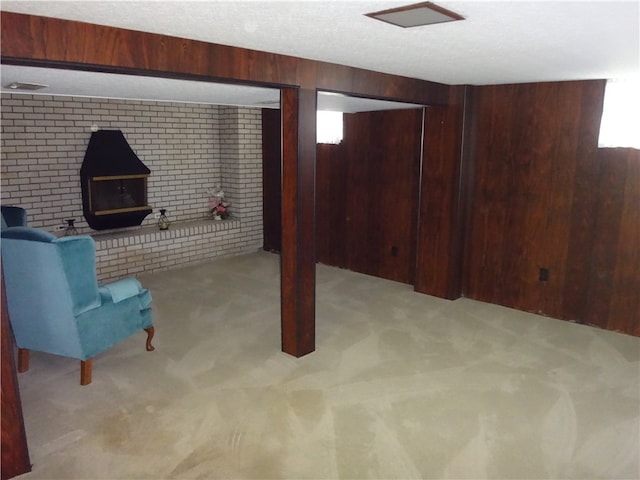 basement featuring light carpet, a wood stove, and wooden walls