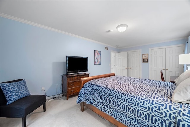 carpeted bedroom featuring multiple closets and ornamental molding