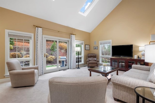 living room featuring light colored carpet, high vaulted ceiling, and a skylight