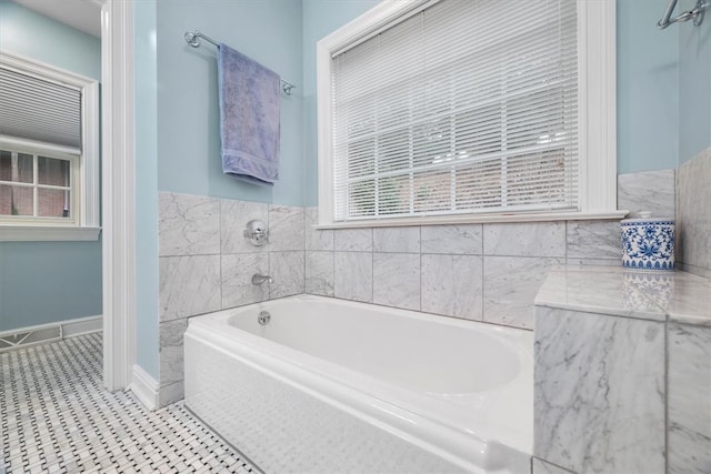 bathroom with tile patterned floors and tiled bath