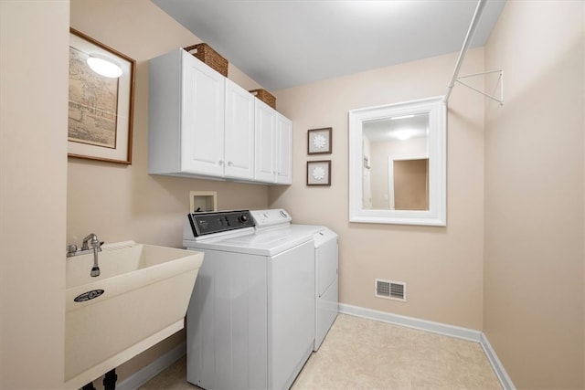 washroom with cabinets, independent washer and dryer, and sink