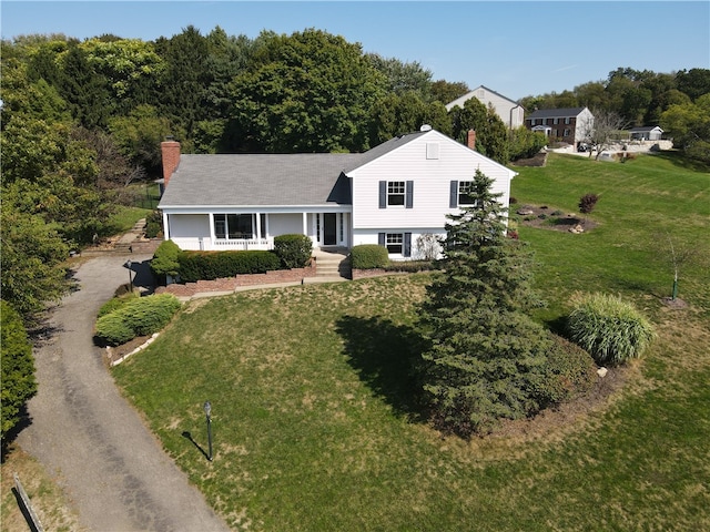 tri-level home featuring a front lawn and a porch