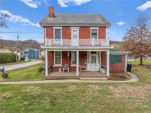 view of front of property featuring a porch, a balcony, and a front yard