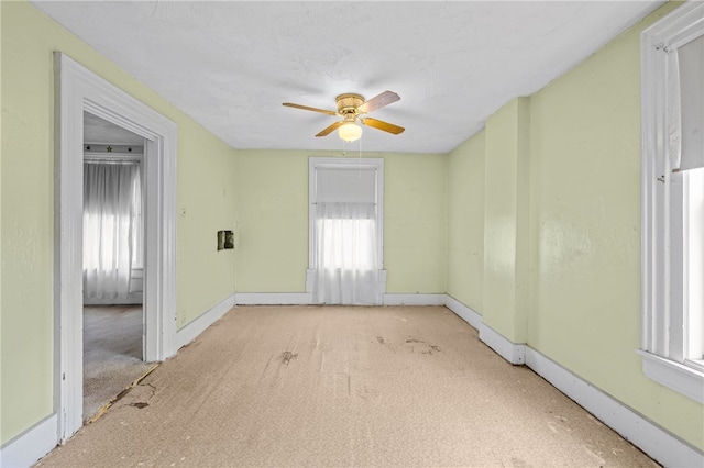 spare room with a wealth of natural light and ceiling fan