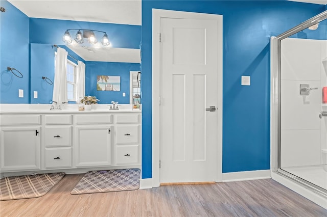 bathroom with hardwood / wood-style floors, vanity, and an enclosed shower