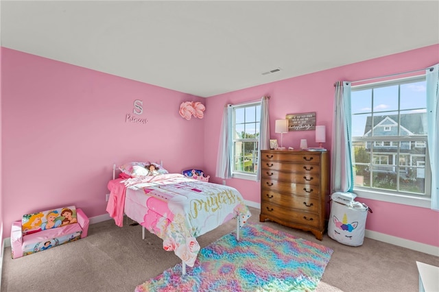 carpeted bedroom featuring multiple windows