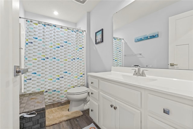 bathroom with vanity, hardwood / wood-style flooring, toilet, and curtained shower