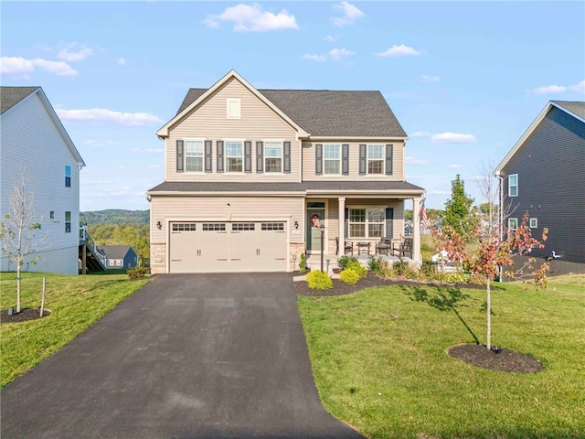 view of front of home with a porch, a garage, and a front yard