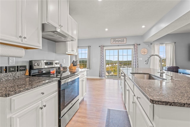 kitchen with a center island with sink, electric stove, sink, light hardwood / wood-style floors, and white cabinetry