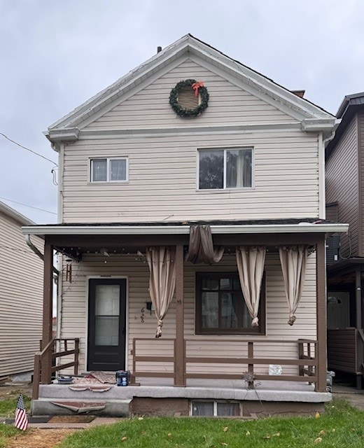 back of house with a yard and a porch