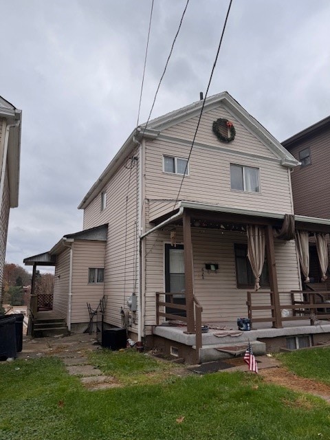 rear view of house with a lawn and covered porch