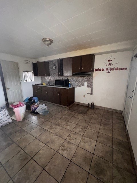 kitchen featuring tasteful backsplash, dark brown cabinets, and tile patterned flooring