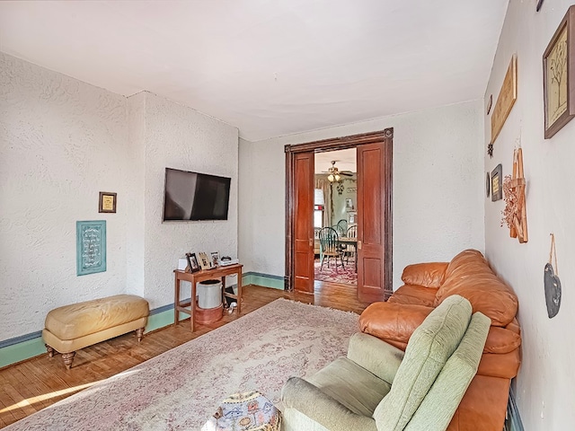 living room with ceiling fan and wood-type flooring