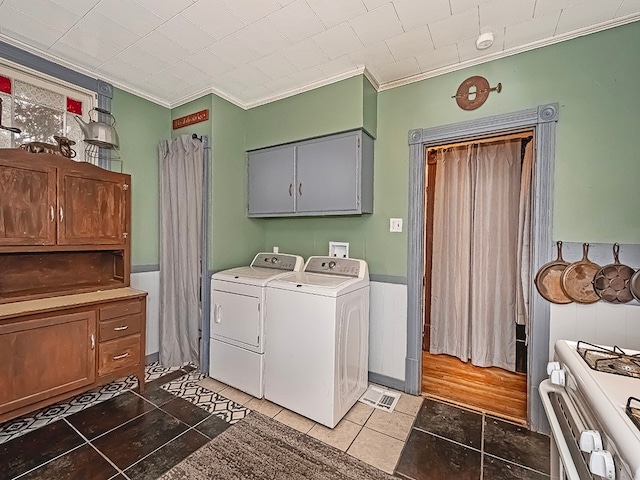 washroom featuring separate washer and dryer, dark tile patterned flooring, and ornamental molding