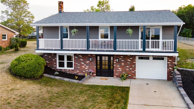 view of front of home with a garage, a balcony, and a front lawn