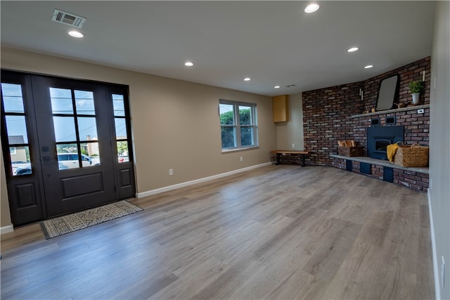 interior space with brick wall and light hardwood / wood-style flooring