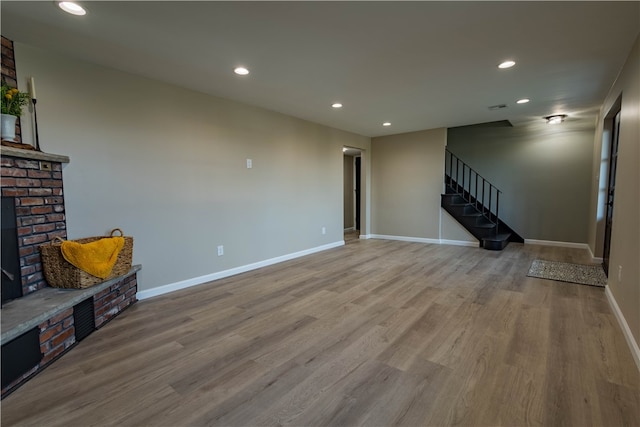 living room with hardwood / wood-style floors and a brick fireplace