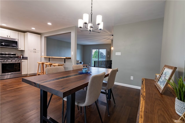 dining area with dark hardwood / wood-style flooring and a chandelier