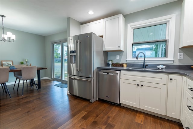 kitchen featuring pendant lighting, a healthy amount of sunlight, white cabinetry, and stainless steel appliances