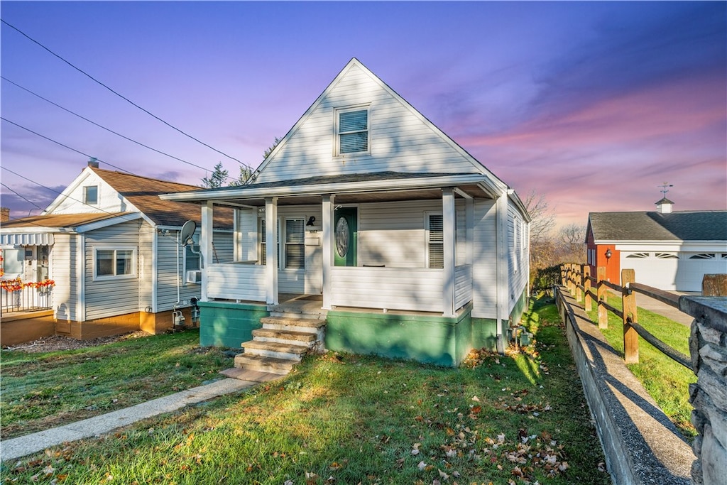 bungalow-style house with covered porch and a lawn