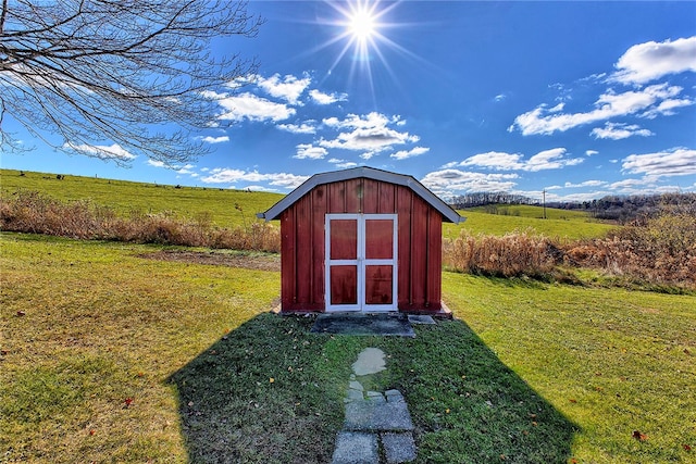 view of outdoor structure featuring a yard and a rural view