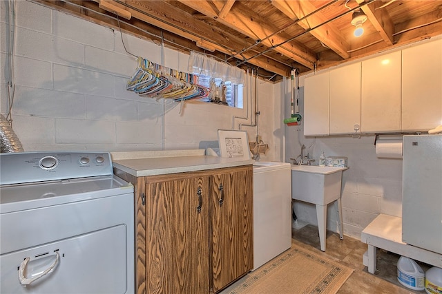 clothes washing area with cabinets and washing machine and clothes dryer