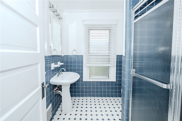 bathroom featuring tile patterned floors, tile walls, and sink