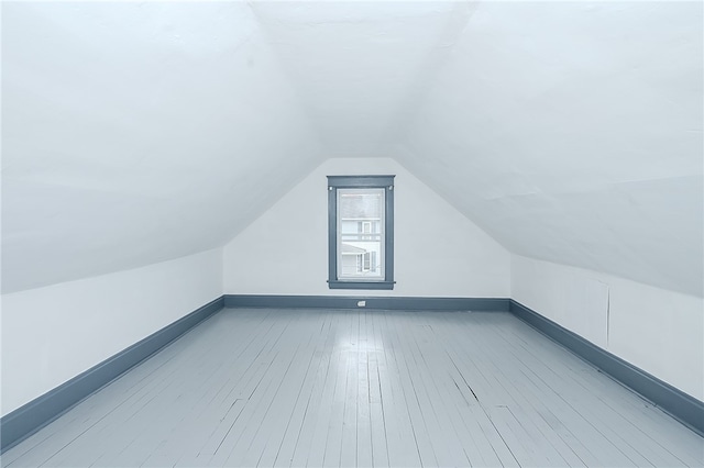 additional living space featuring light hardwood / wood-style flooring and lofted ceiling