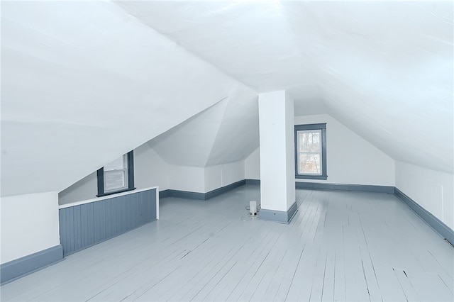 additional living space featuring wood-type flooring and vaulted ceiling