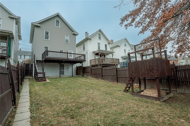 rear view of house with a yard and a deck