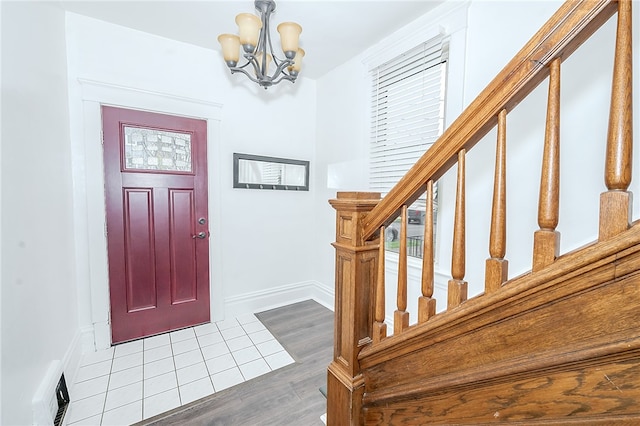 entryway with wood-type flooring and an inviting chandelier