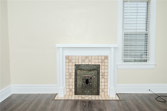 interior details featuring a tile fireplace and hardwood / wood-style floors