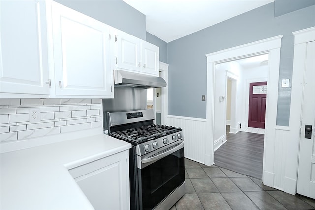 kitchen featuring tasteful backsplash, gas range, hardwood / wood-style floors, and white cabinets