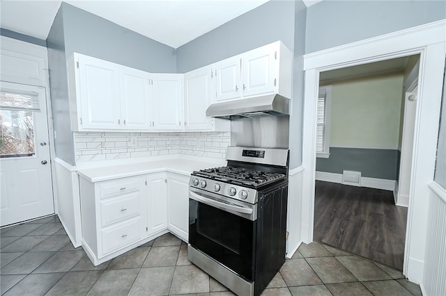 kitchen with tasteful backsplash, stainless steel range with gas cooktop, white cabinets, and light tile patterned floors