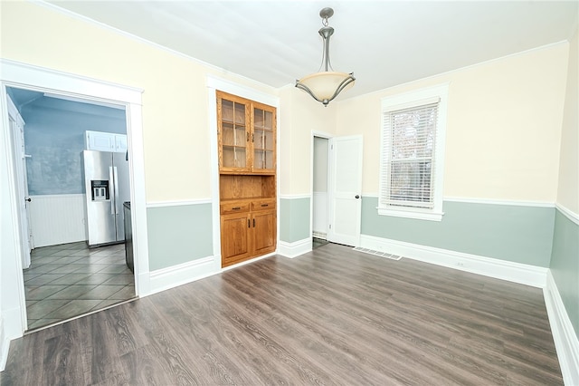 unfurnished dining area with crown molding and dark wood-type flooring