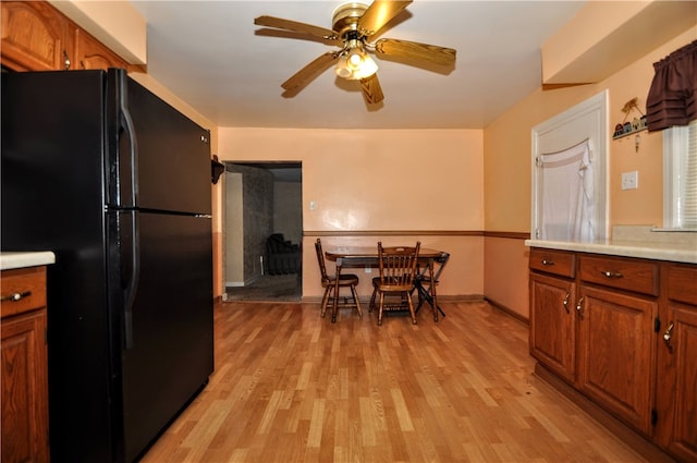 kitchen with black refrigerator, light wood-type flooring, and ceiling fan