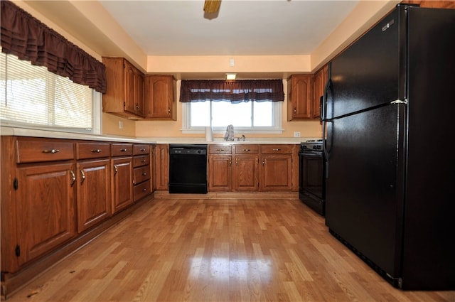 kitchen with sink, black appliances, and light wood-type flooring