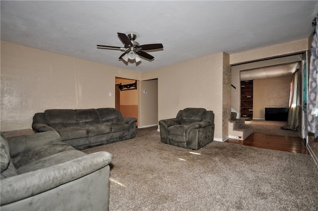 living room featuring carpet flooring, a large fireplace, and ceiling fan